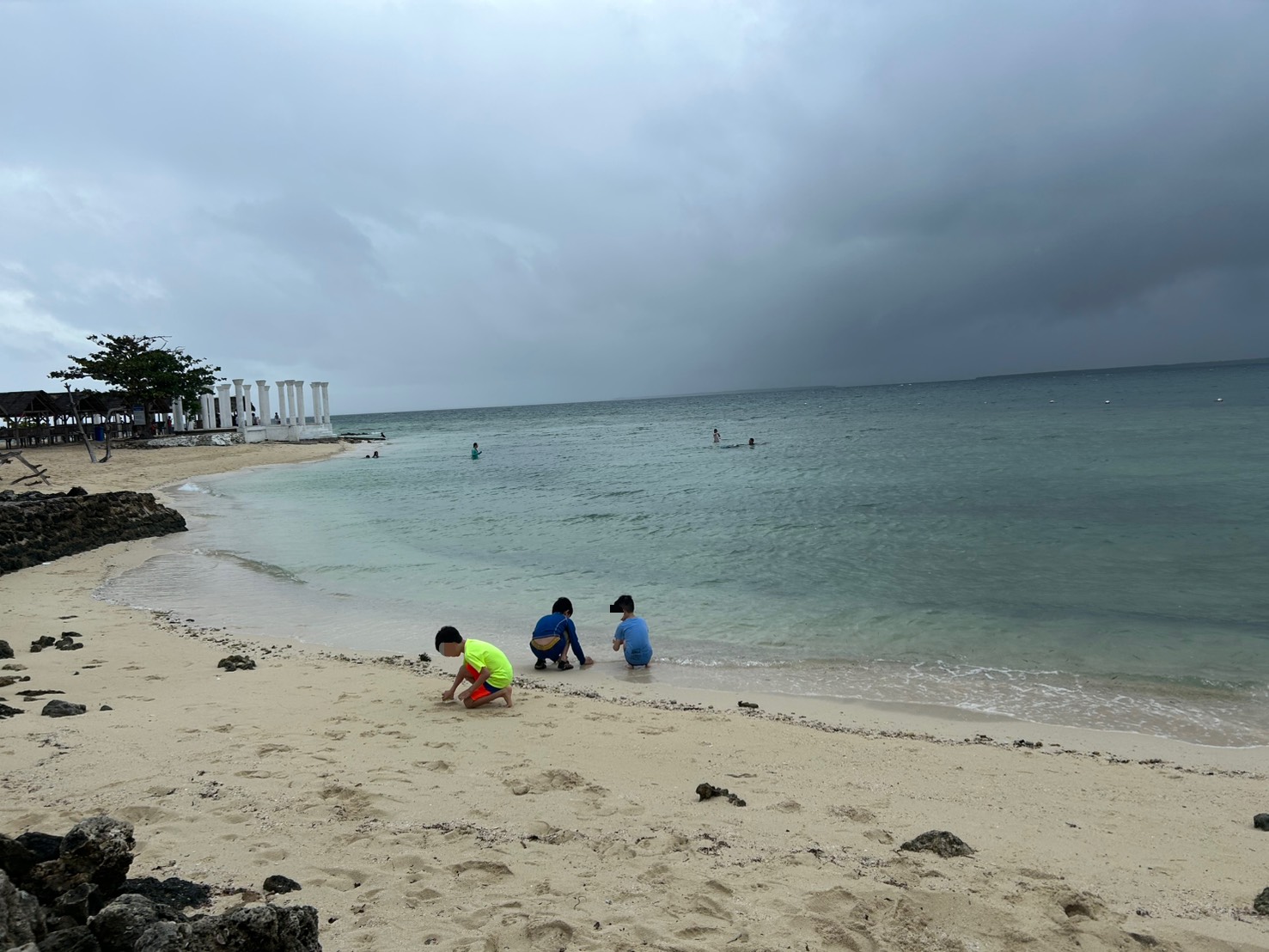 ビーチで貝殻を拾う子どもたちと海辺の風景